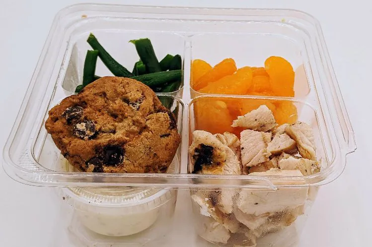 grilled ranch chicken and oranges signifying Meal Village's premade kids meal services