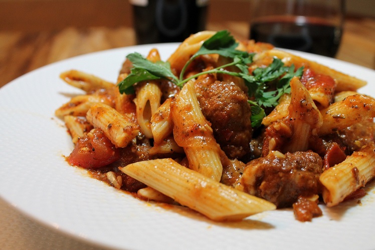 Penne pasta with grilled Italian sausage, Roma tomatoes, black olives and fresh basil.