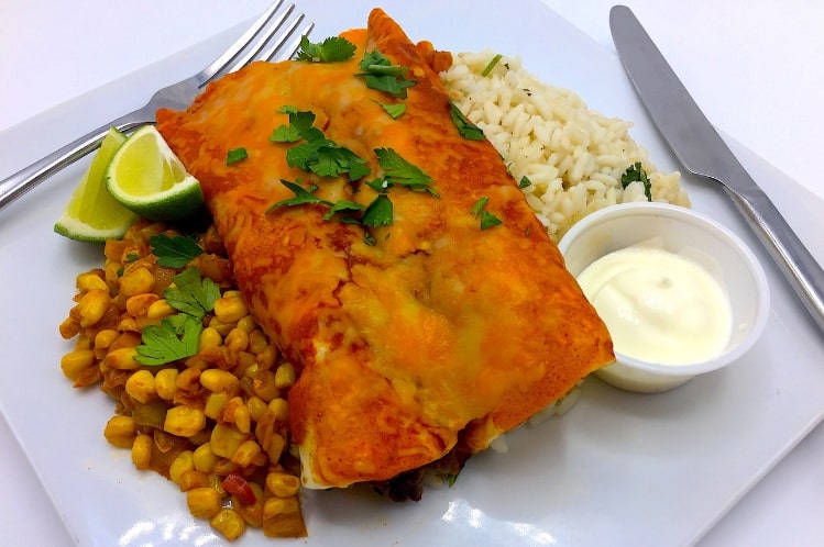 Beef and bean enchiladas with melted cheese, spicy corn and white rice.