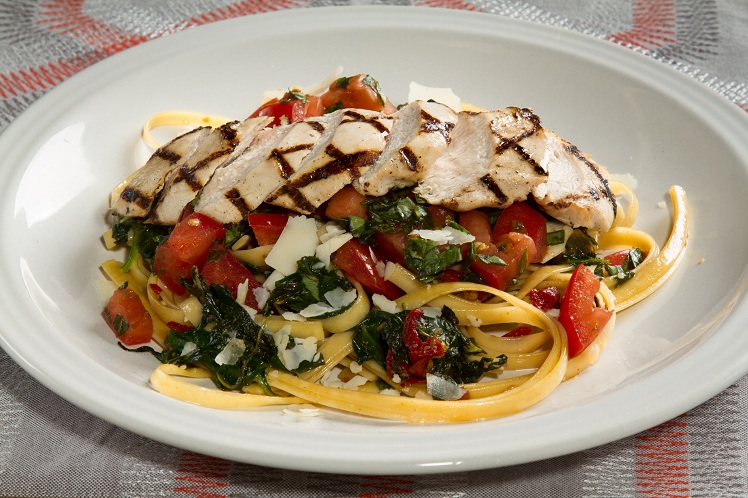 Sliced grilled chicken over fettuccine with spinach and basil tomato bruschetta relish.