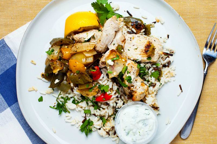 Grilled Greek chicken kabobs with bell peppers and onions, served with lemon wild rice pilaf, feta cheese and tzatziki sauce from Meal Village.