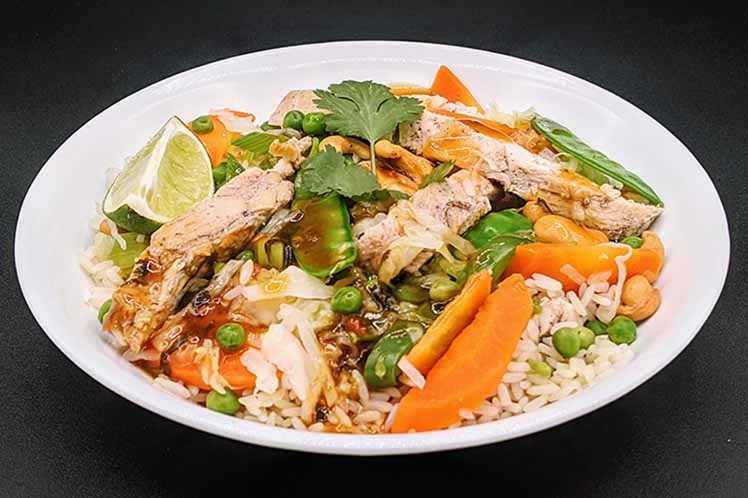 Cashew chicken stir fry with vegetables, toasted cashews and white rice.