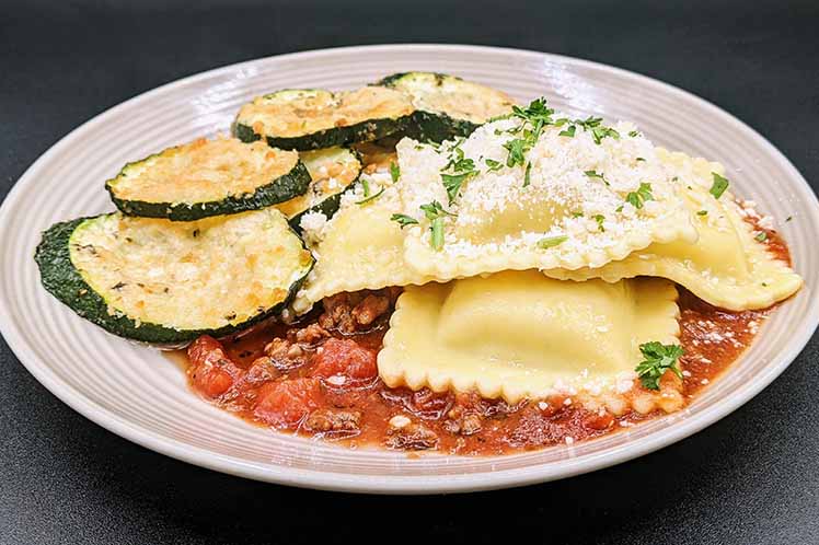 Four cheese ravioli with marinara and ground beef, plated with parmesan breaded zucchini planks.